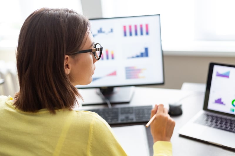 A woman reviews trucking data and analytics on a computer in an office. 