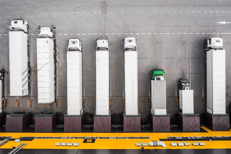 An aerial view of a group of semi-trucks at a distribution center. 